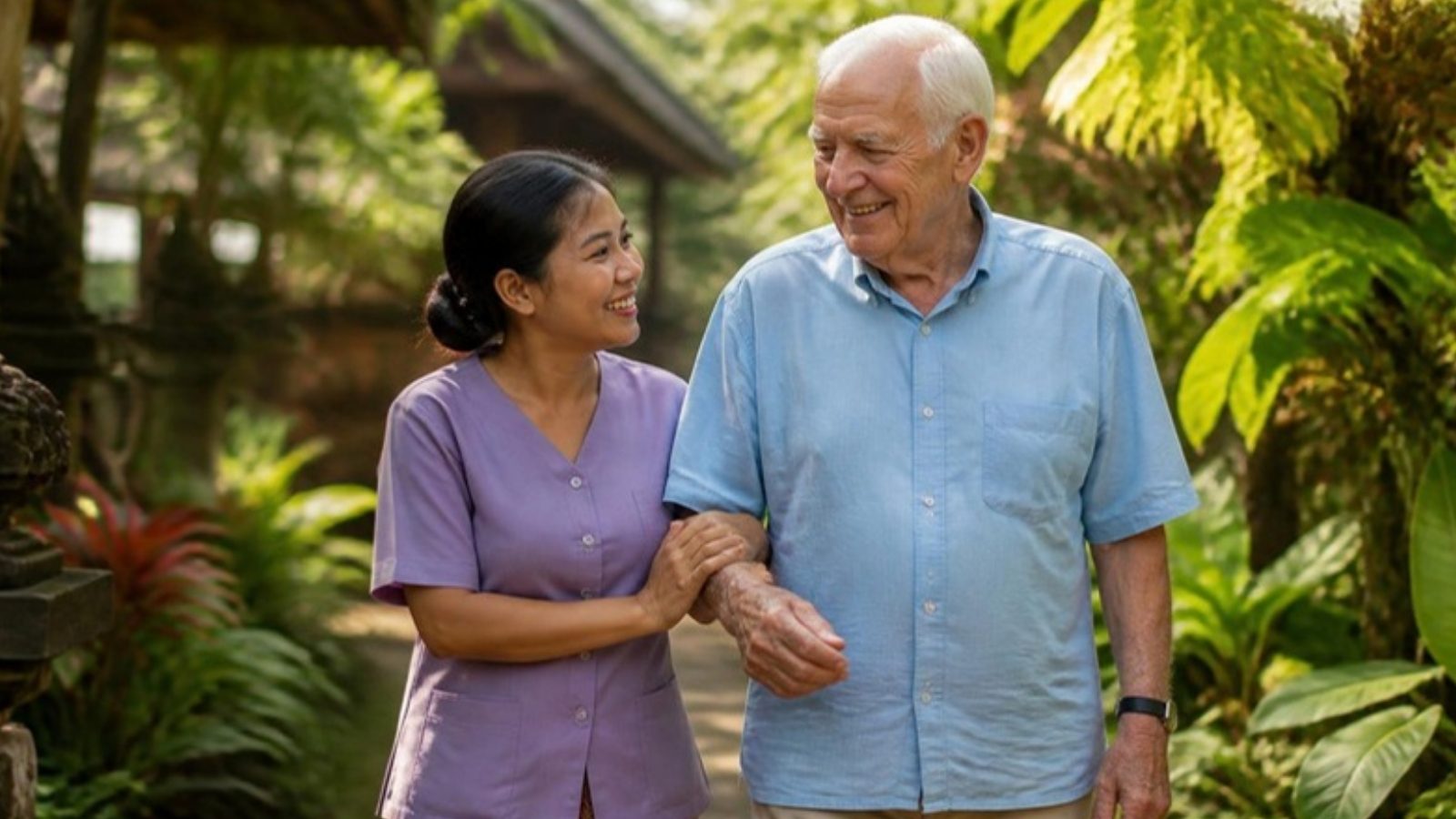 Caregiver walking with an older man in a Bali garden