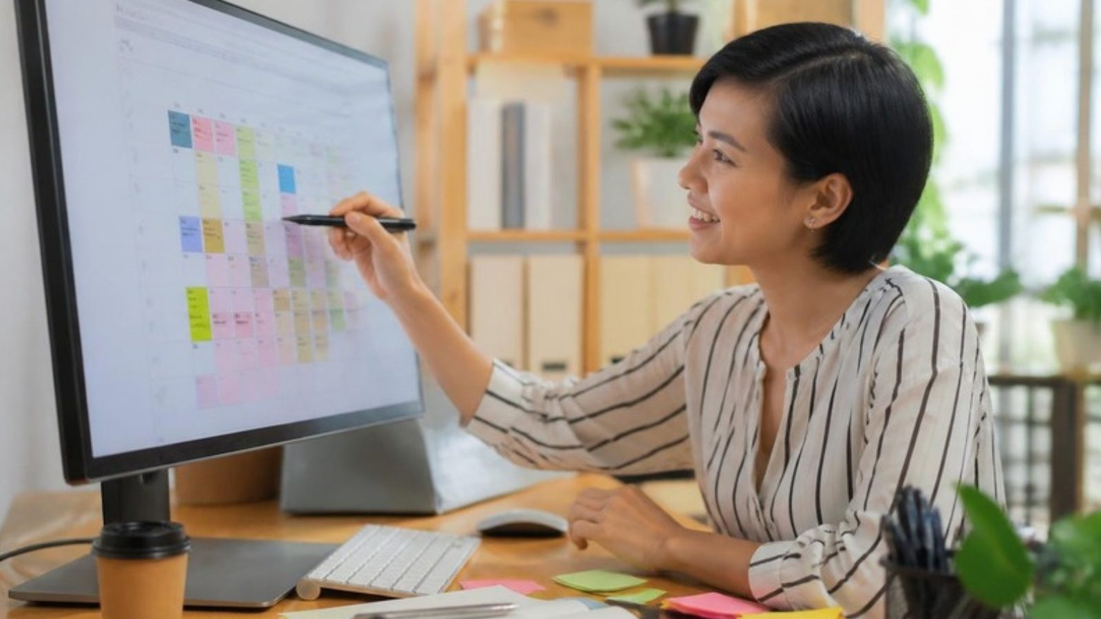 Virtual assistant organising a colourful calendar on a monitor